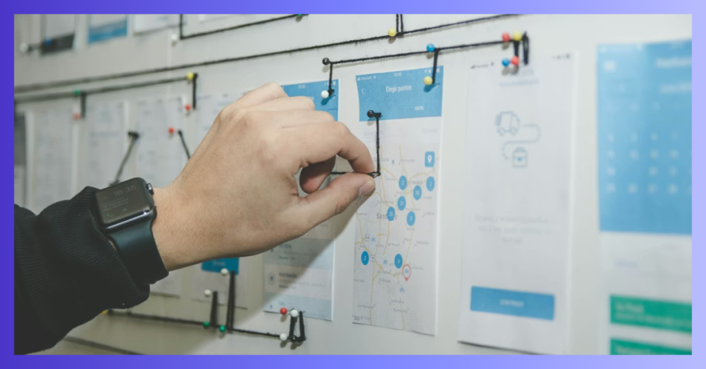 Un homme pose une épingle sur un tableau avec des visuels papier